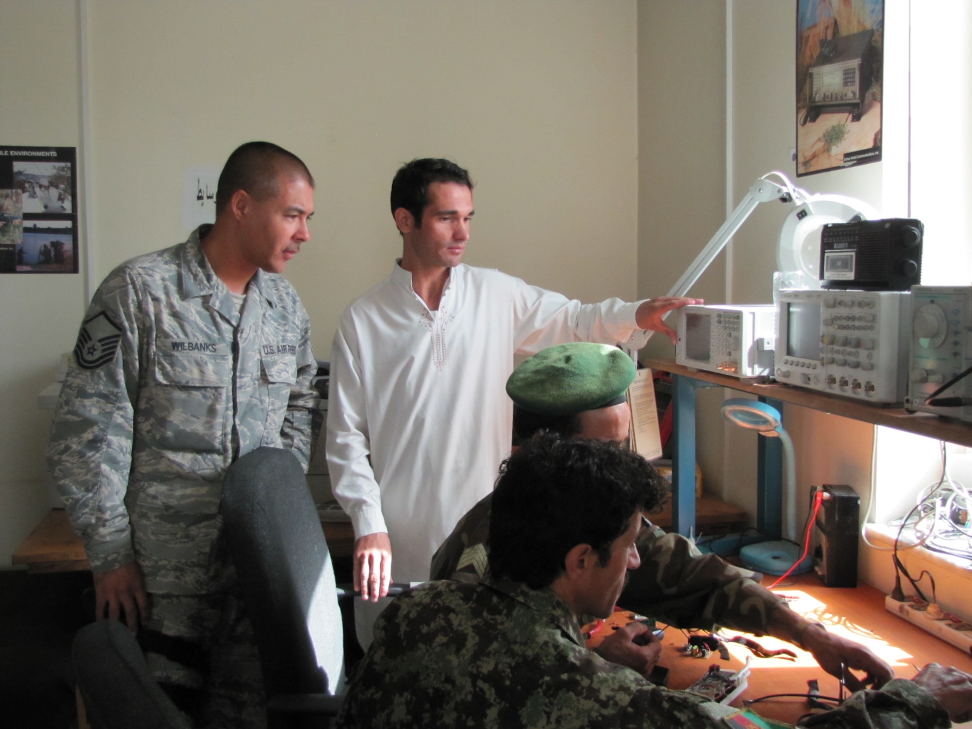KABUL, Afghainstan - MSgt. Jack Wilbanks, a Combined Air Power Transition Force Comm mentor watches as his Afghan counterparts work on a radio on the Afghan Air Force.  (U.S. Air Force photo by Capt. Rob Leese/RELEASED).