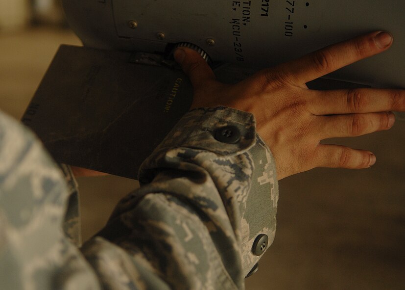 KUNSAN AIR BASE, Republic of Korea -- Senior Airman Jareid Juarbe, 80th Aircraft Maintenance Squadron weapons load crew member, tightens the fin of an AIM-120 missile here Aug. 25, during exercise Beverly Midnight 10-03. All fins on missiles have to be securely fastened so that they do not come off during flight and cause the missile to malfunction. (U.S. Air Force photo/Senior Airman Ciara Wymbs) 