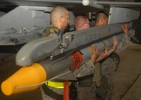 KUNSAN AIR BASE, Republic of Korea -- Weapons load crew members work together to load an AIM-120 missile to an F-16 here Aug. 25, during exercise Beverly Midnight 10-03.  Members of load crews have to precisely and promptly load missiles for flight generation. (U.S. Air Force photo/Senior Airman Ciara Wymbs)