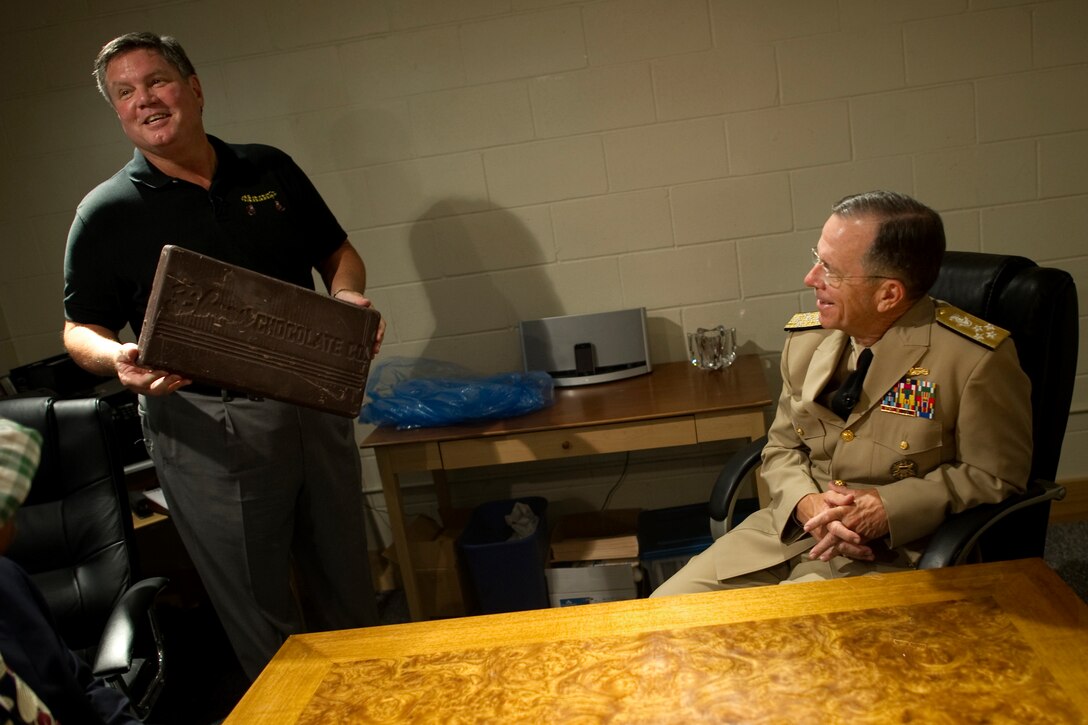 Bob Carmody, owner of Diana's Bananas, shows Navy Adm. Mike Mullen, chairman of the Joint Chiefs of Staff, a 10-pound piece of chocolate used to produce the company's chocolate-covered bananas during a visit to the factory in Chicago, Aug 25, 2010. Carmody secured a $2 million small business loan through the Veterans Administration to expand his business and hire veterans.