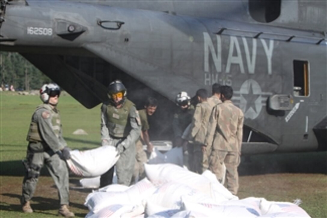 U.S. Navy sailors with Helicopter Mine Countermeasures Squadron 15, Detachment 2 help Pakistani soldiers offload relief supplies from a U.S. Navy MH-53E Sea Dragon helicopter during humanitarian relief efforts in Khyber-Pakhtunkhwa province, Pakistan, on Aug. 21, 2010.  