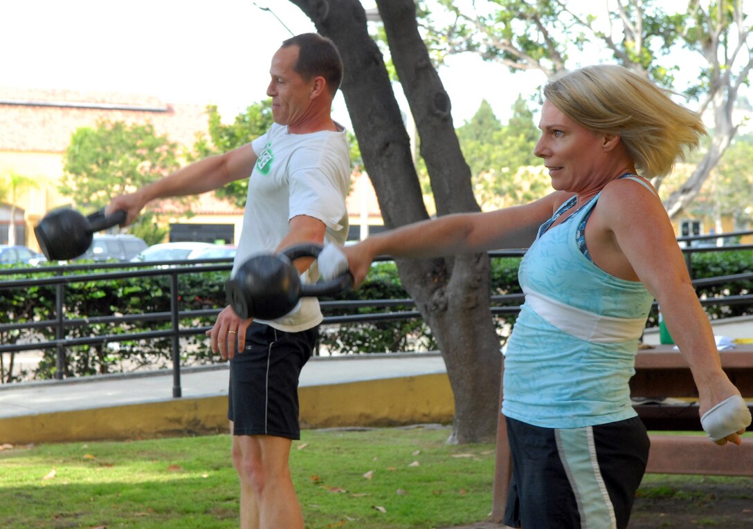 Rod Bowman and Teri Smallwood are conscious of their proper form as they do kettlebell swings during a kettlebell class Aug. 25, outside the depot Fitness Center.