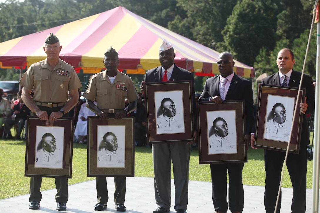 Members of the honorary party show off autographed portraits of retired Sgt. Maj. Gilbert “Hashmark” Johnson, during a ceremony honoring African-American Marines who served in the Marine Corps in the 1940s aboard Montford Point Camp, now known as Camp Johnson, Aug. 26.  Montford Point Camp was renamed after Johnson in 1974.