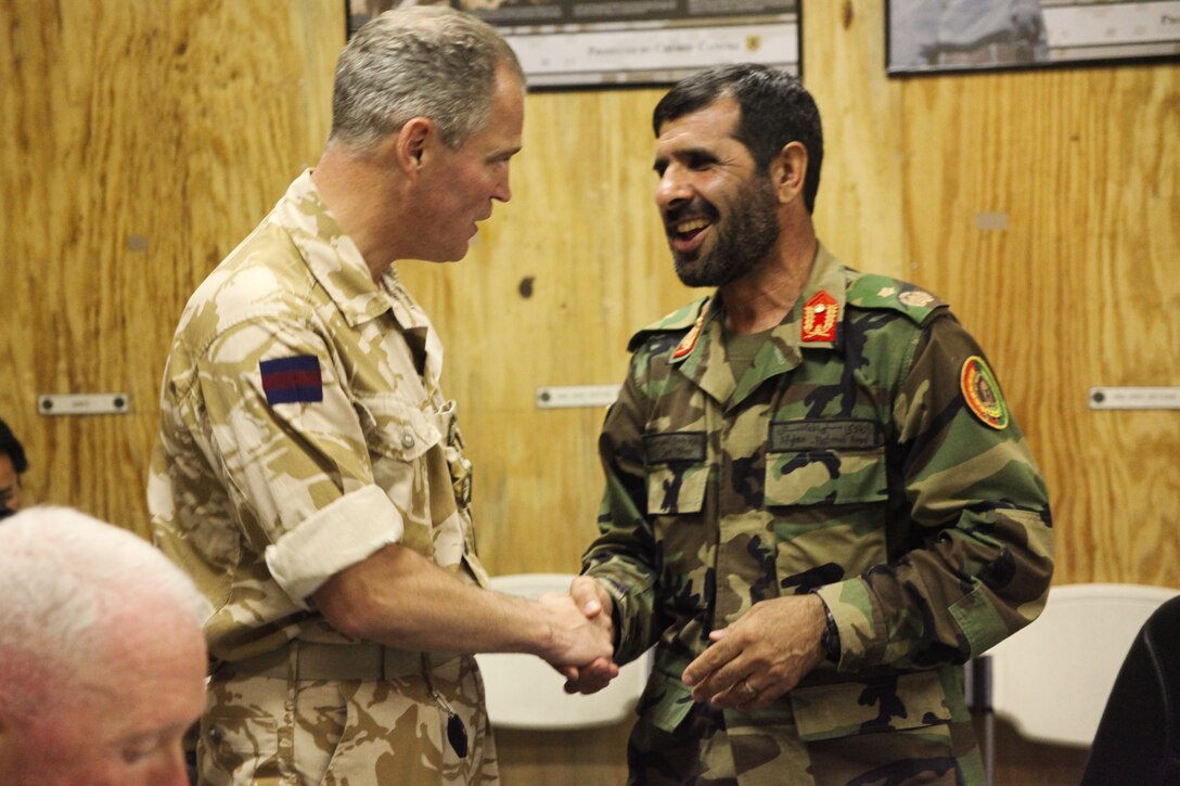 Brigadier George Norton, Regional Command Southwest deputy commander, and Brig. Gen. Malouk, 215th Corps commander, greet each other during an iftar celebration at Camp Leatherneck, Afghanistan Aug. 26.  Iftar, an evening meal between friends and family, ends the fast held from dawn to sunset every day during the holy Islamic month of Ramadan.::r::::n::