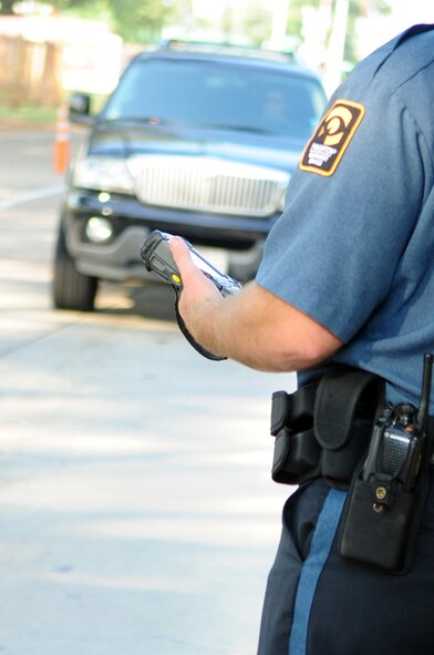 BARKSDALE AIR FORCE BASE, La. – Officer J.P. Kennedy, Pinkerton Security Service, prepares to scan the identification card of a Barksdale Airman at the Shreveport Gate Aug. 26. Beginning Sept. 6, all Barksdale personnel are required to have their identification cards registered in the Defense Biometric Identification System. ID card holders can register in DBIDS at the West or East Gate visitor's centers, the Military Personnel Section or the 917th customer service center. (U.S. Air Force photo by Senior Airman Joanna M. Kresge)