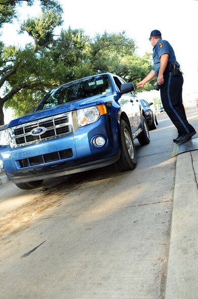 BARKSDALE AIR FORCE BASE, La. – Officer J.P. Kennedy, Pinkerton Security Service, requests the identification card of Barksdale personnel at the Shreveport Gate Aug. 26. Beginning Sept. 6, all Barksdale personnel are required to have their identification cards registered in the Defense Biometric Identification System. ID card holders can register in DBIDS at the West or East Gate visitor's centers, the Military Personnel Section or the 917th customer service center. (U.S. Air Force photo by Senior Airman Joanna M. Kresge)