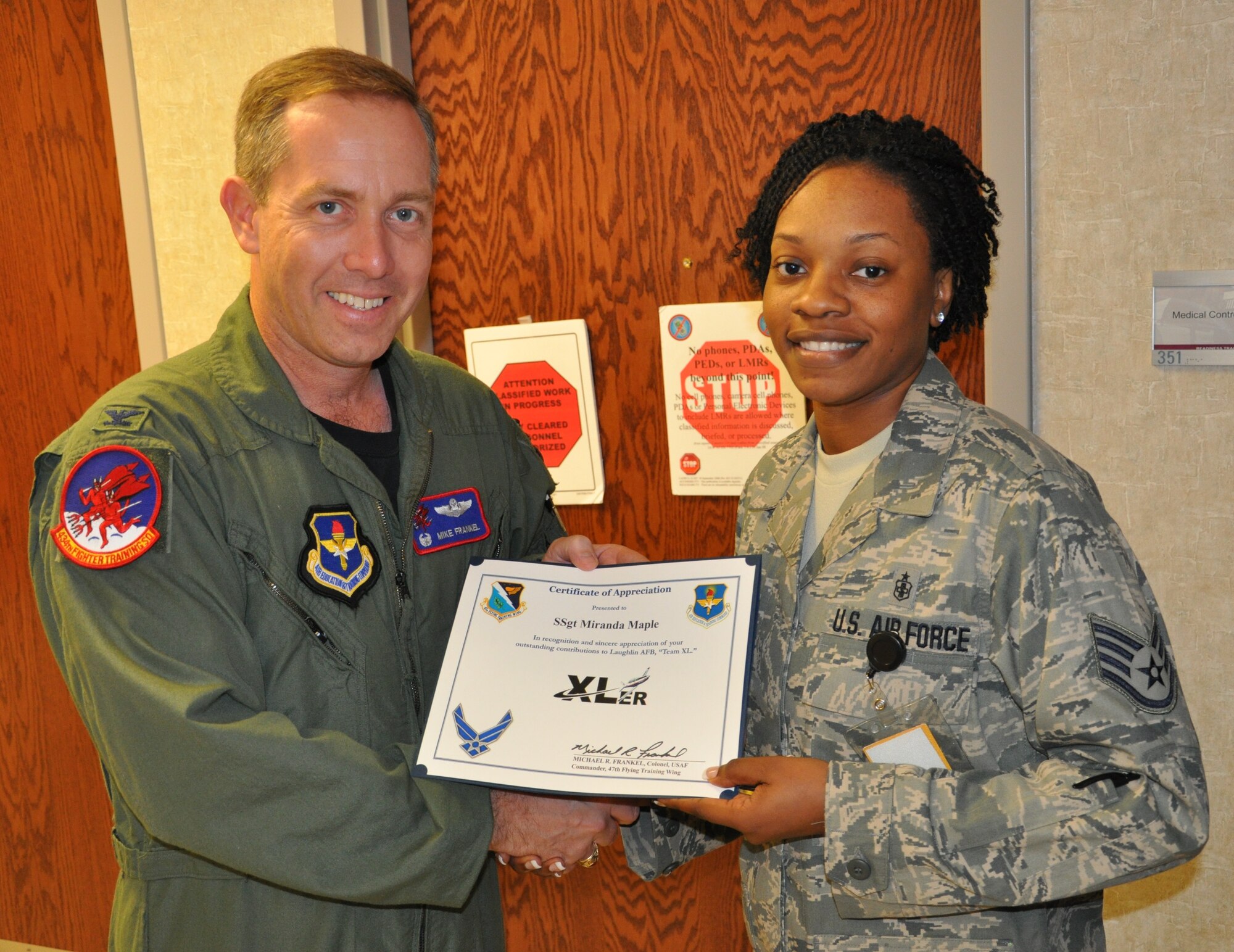 LAUGHLIN AIR FORCE BASE, Texas –Staff Sgt. Miranda Maple, 47th Medical Support Squadron, is presented the XLer of the Week award by Col. Michael Frankel, 47th Flying Training Wing commander, Aug. 25. The XLer is a weekly award chosen by 47th FTW leadership and given to individuals who consistently make outstanding contributions to Laughlin and their unit. (U.S. Air Force photo by Airman 1st Class Blake Mize)
