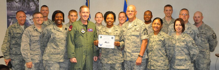 LAUGHLIN AIR FORCE BASE, Texas – Staff Sgt. Miranda Maple, 47th Medical Support Squadron, poses with fellow members of her squadron after being presented the XLer of the Week award by Col. Michael Frankel, 47th Flying Training Wing commander, Aug. 25. The XLer is a weekly award chosen by 47th FTW leadership and given to individuals who consistently make outstanding contributions to Laughlin and their unit. (U.S. Air Force photo by Airman 1st Class Blake Mize)