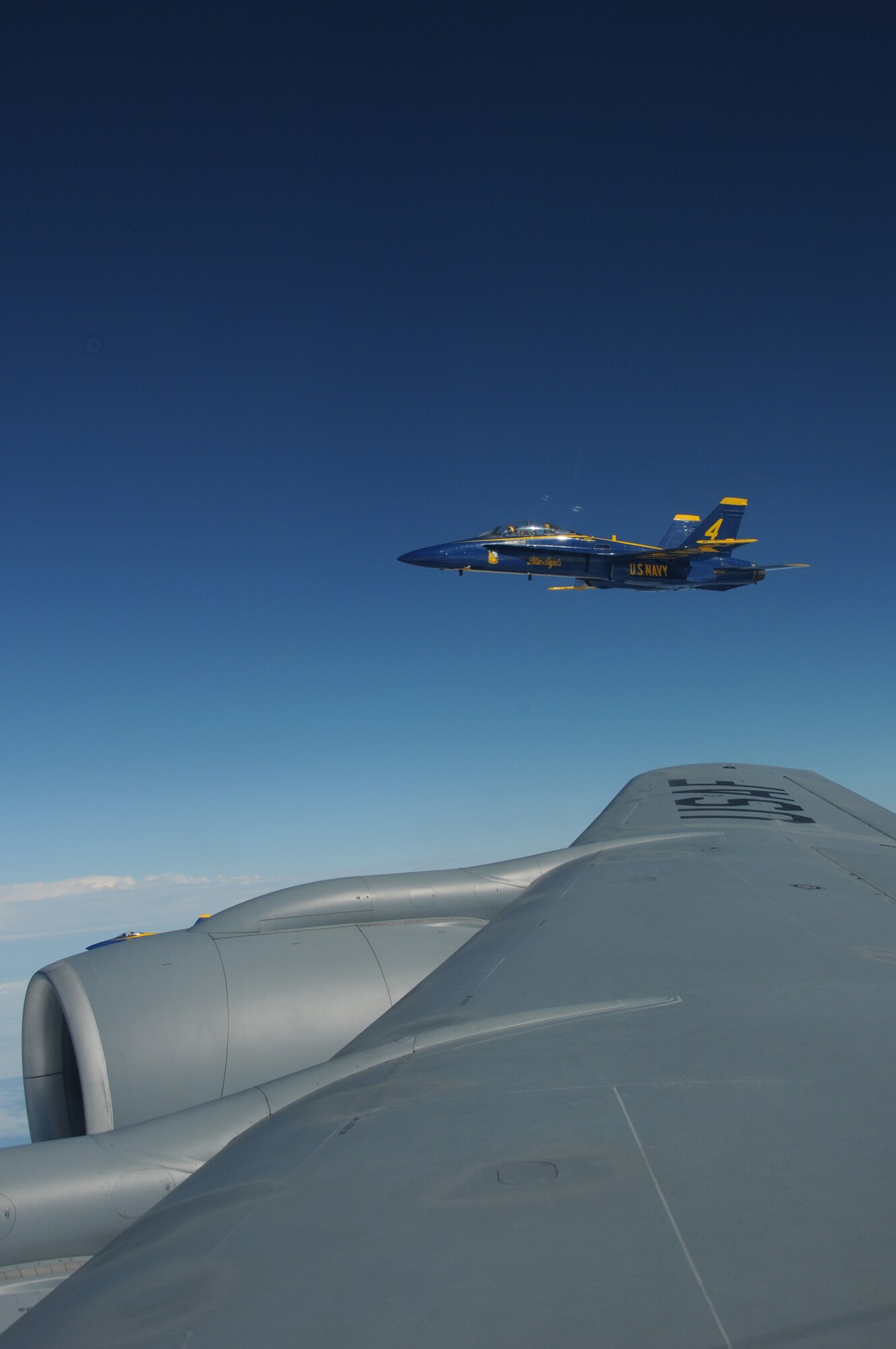 An F/A-18 Hornet belonging to the United States Navy's Flight Demonstration Squadron, the Blue Angels, forms up on the wing of a KC-135R Stratotanker over the Eastern United States on August 25, 2010. The tanker aircraft and crew are from the 157th Air Refueling Wing at Pease Air National Guard Guard Base, New Hampshire. The Blue Angels are headed to the 2010 Boston New-England Airshow  at Pease International Airport on August 28th-29th 2010. Although the NH Air National Guard won't be hosting the airshow, they will be providing logistical support to the Blue Angels and other military aircraft. (U.S. Air Force photo/Staff Sgt. Curtis J. Lenz)