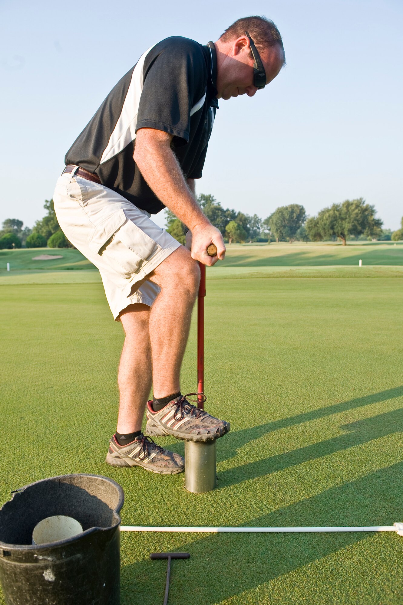 BARKSDALE AIR FORCE BASE, La. -- William Duckworth, Fox Run golf course superintendent, relocates a cup on one of the greens Aug. 25. The cups are moved around often to vary the course for the players as well as to prevent grass damage from high foot traffic. (U.S. Air Force photo by Senior Airman Chad Warren)(RELEASED)