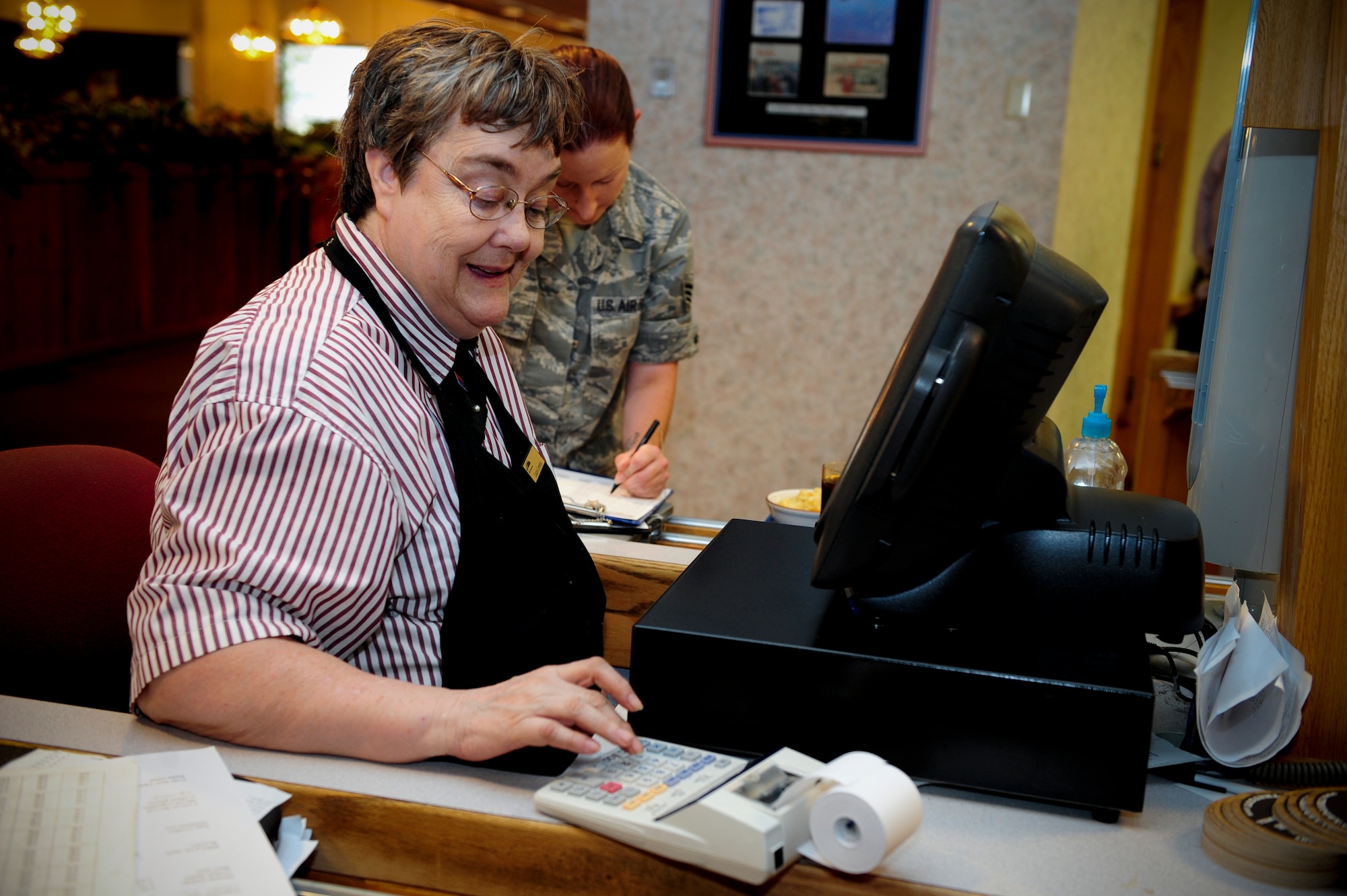 ELLSWORTH AIR FORCE BASE, S.D. – Lucia Lewton, 28th Force Support Squadron Bandit Inn food service attendant, adds up the cost of a customer’s food, Aug. 20. Mrs. Lewton employed by BH Services and is contracted by the Air Force to help operate the Bandit Inn Dining Facility. (U.S. Air Force photo/Senior Airman Corey Hook) 