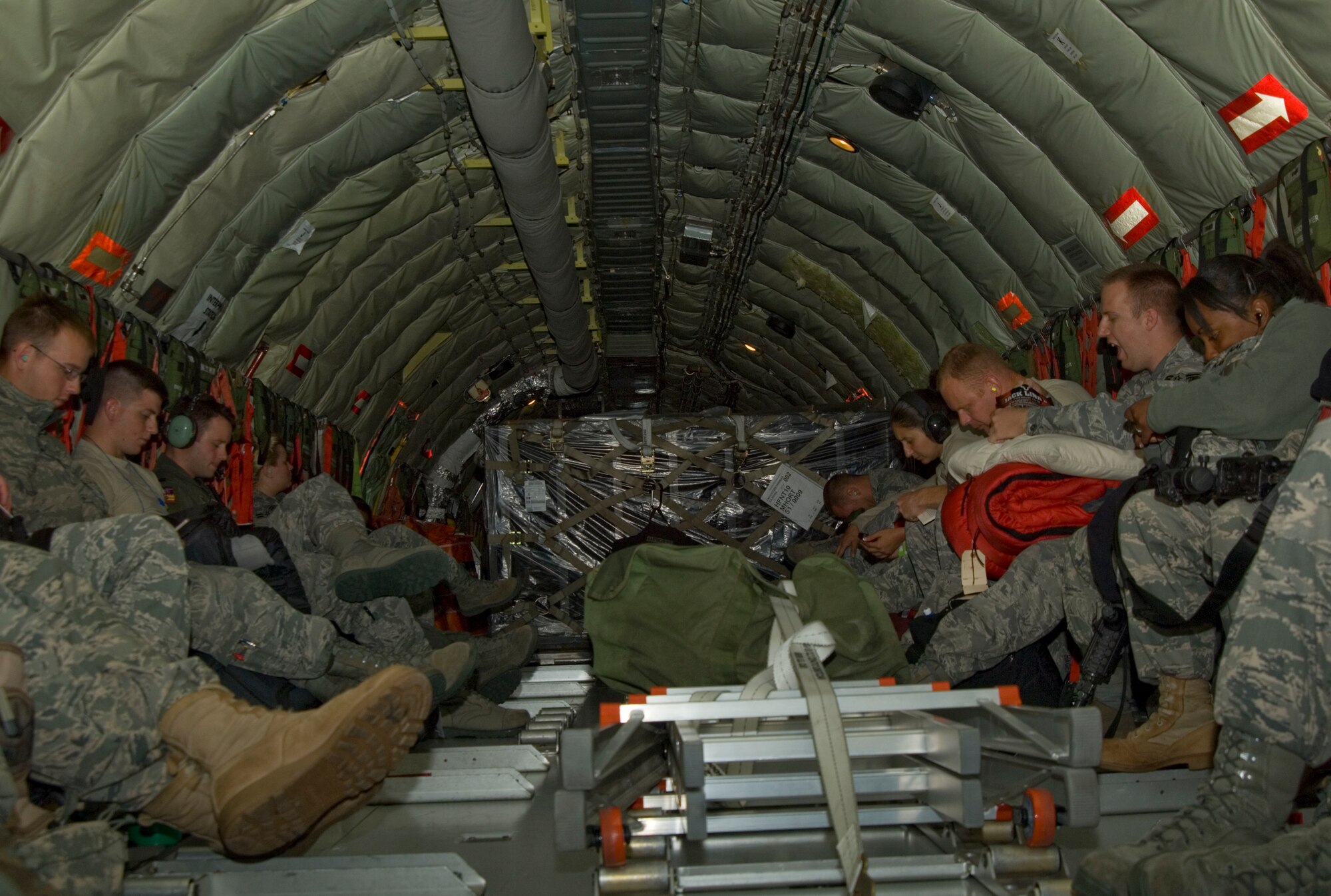 McConnell Airmen rest during a flight returning to McConnell Aug. 18, 2010, after they participated in a two-day forward deployment to Grand Forks Air Force Base, N.D.  The deployment was conducted as part of an operational readiness exercise which required more than 100 Airmen from various units and squadrons including security forces, personnel support for contingency operations, maintenance and logistics.  (U.S. Air Force photo/Senior Airman Abigail Klein)