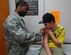 LANGLEY AIR FORCE BASE, Va. -- Staff Sgt. Lavarous Johnson, 633d Medical Operations Squadron, places a bandage on Preston Earley following a vaccination at the Langley Allergy and Immunizations Clinic Aug. 24. The clinic offers all shots needed to fulfill Virginia state requirements for children to attend school and day care programs. (U.S. Air Force photo/Airman 1st Class Jason J. Brown)