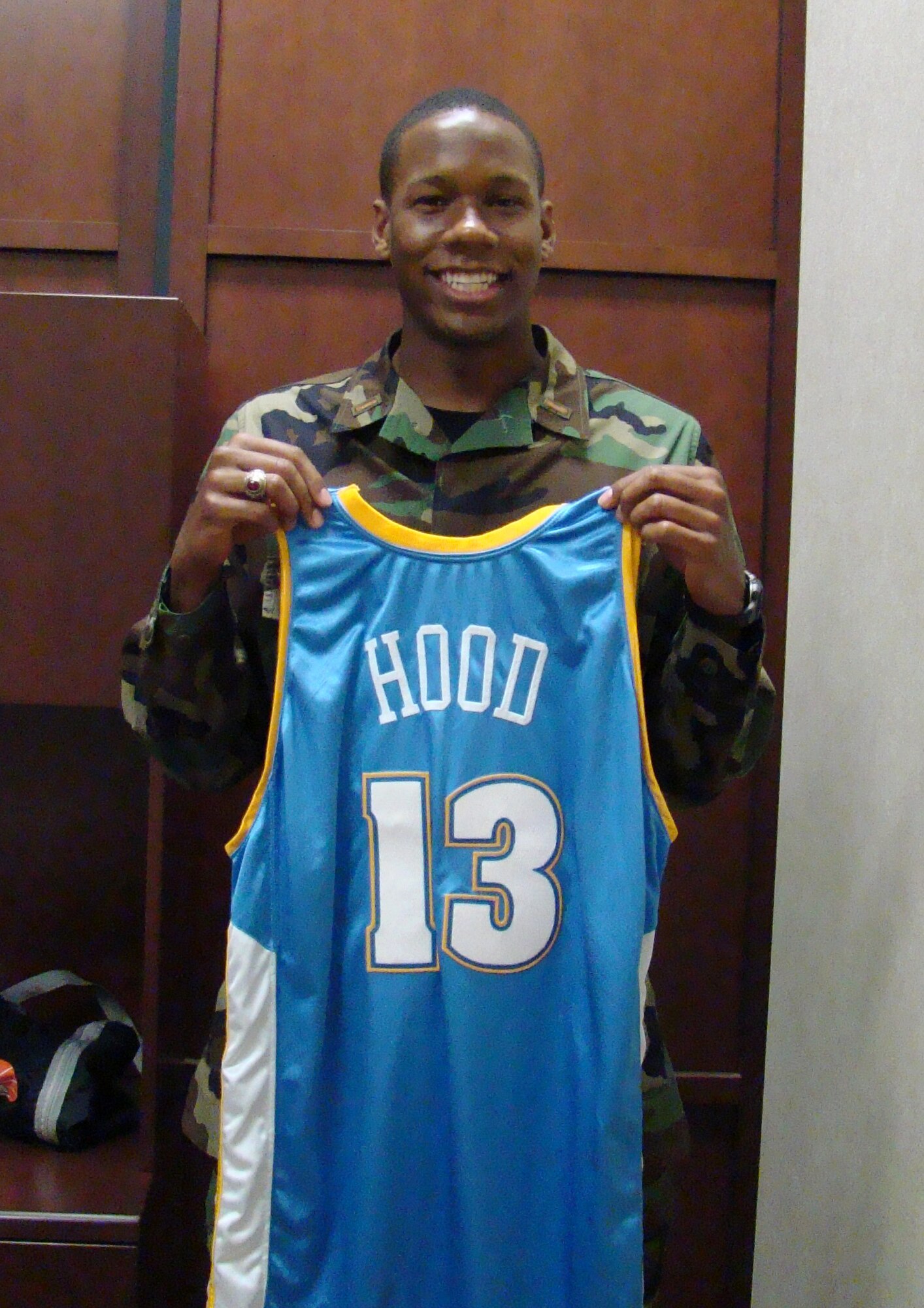 Then 2nd Lt. Antoine Hood shows off his Denver Nuggets jersey. Lieutenant Hood was offered a spot on the NBA team and played professionally before he returned to active duty to fulfill his service commitment. The Captain is now eligible to play again and is planning to return to the league this season. (Courtesy photo)
