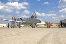 MINOT AIR FORCE BASE, N.D. -- Darrell Stambaugh  (far left) and Mary Onstott, both of Transient Alert, perform routine aircraft maintenance, while Airman 1st Class David Peterson, 5th Logistics Readiness Squadron refueling equipment operator, refuels an A-10 Thunderbolt II from Whiteman AFB, Mo., here Aug. 24.  The A-10 Thunderbolt II received modifications at Mountain Home AFB, Id., and made the stop for routine maintenance and fuel en route to Whiteman AFB, Mo.  (U.S. Air Force photo by Staff Sgt. Miguel Lara III)