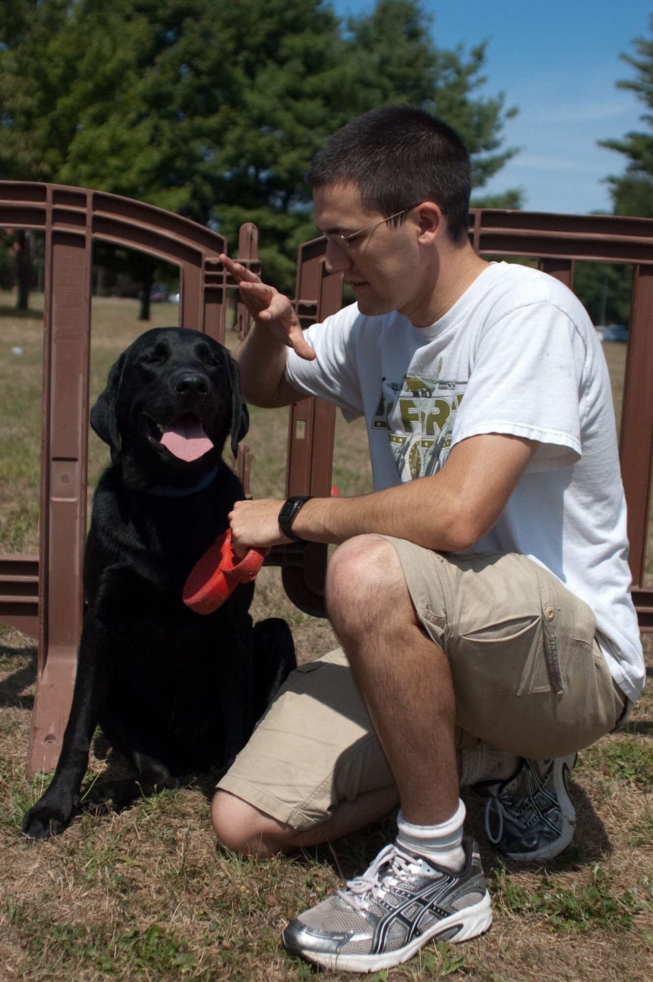 HANSCOM AIR FORCE BASE, Mass. – Patrick Gernert shades his dog, Hershey, from the sun during the Community Dog Show at Memorial Park on Aug. 21. Owners brought their dogs to compete in contests such as dog and owner look-alike, cutest and best dressed. (U.S. Air Force photo by Lance Beebe)