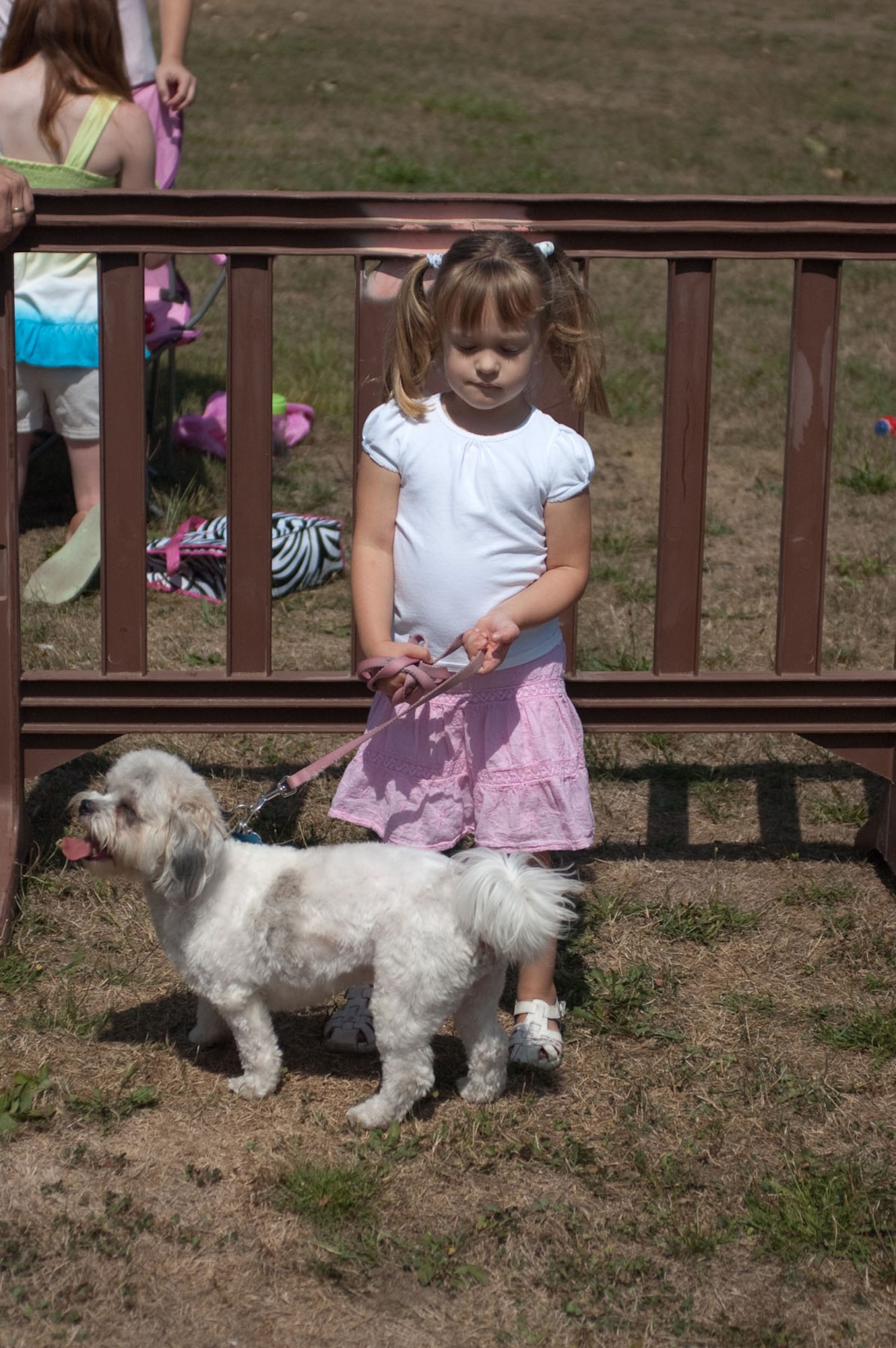 HANSCOM AIR FORCE BASE, Mass. – Lilly Hall holds on tightly to her dog, Lexie, during the Community Dog Show at Memorial Park on Aug. 21. Owners brought their dogs to compete in contests such as dog and owner look-alike, cutest and best dressed. (U.S. Air Force photo by Lance Beebe)