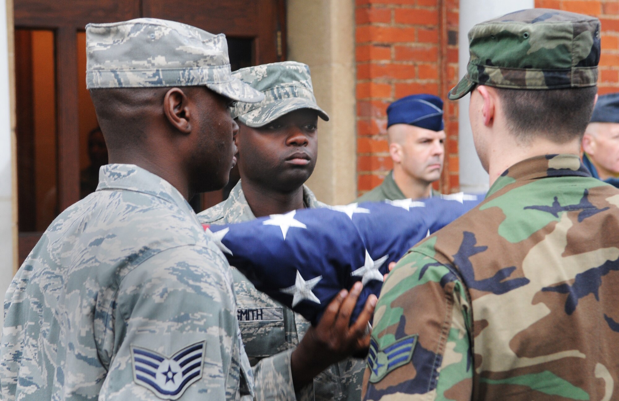 RAF MILDENHALL, England -- Staff Sgt. Juante Smith, 100th Communications Squadron, secures the colors with Staff Sgt. Mervin Peters, 100th Force Support Squadron (left), and Senior Airman Ryan Timm, 100th Logistics Readiness Squadron, in a Retreat ceremony outside the 100th Air Refueling Wing Headquarters Aug. 26. Airmen from across the 100th Mission Support Group stood in formation for the retreat. (U.S. Air Force photo/Staff Sgt. Thomas Trower)
