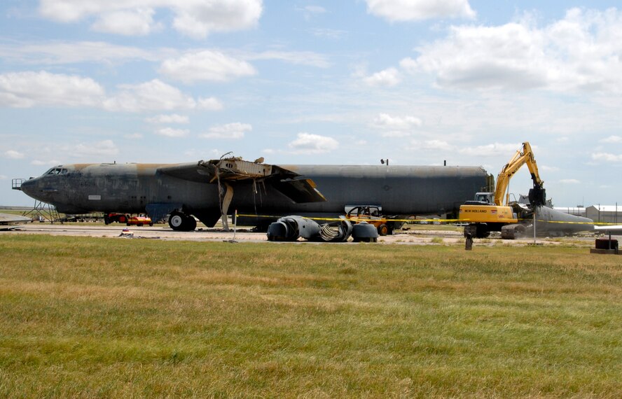 A heavy equipment operator removes the tail section of a B-52G Stratofortress Aug. 25 at Sheppard Air Force Base during a demolition process. The aircraft was identified as "excess" when Sheppard received a newer B-52H to train aircraft maintenance Airmen in Training. Navy Facilities Engineering Command, Engineering Center from Port Hueneme, Calif., is overseeing the project. (U.S. Air Force photo/Mike Litteken)