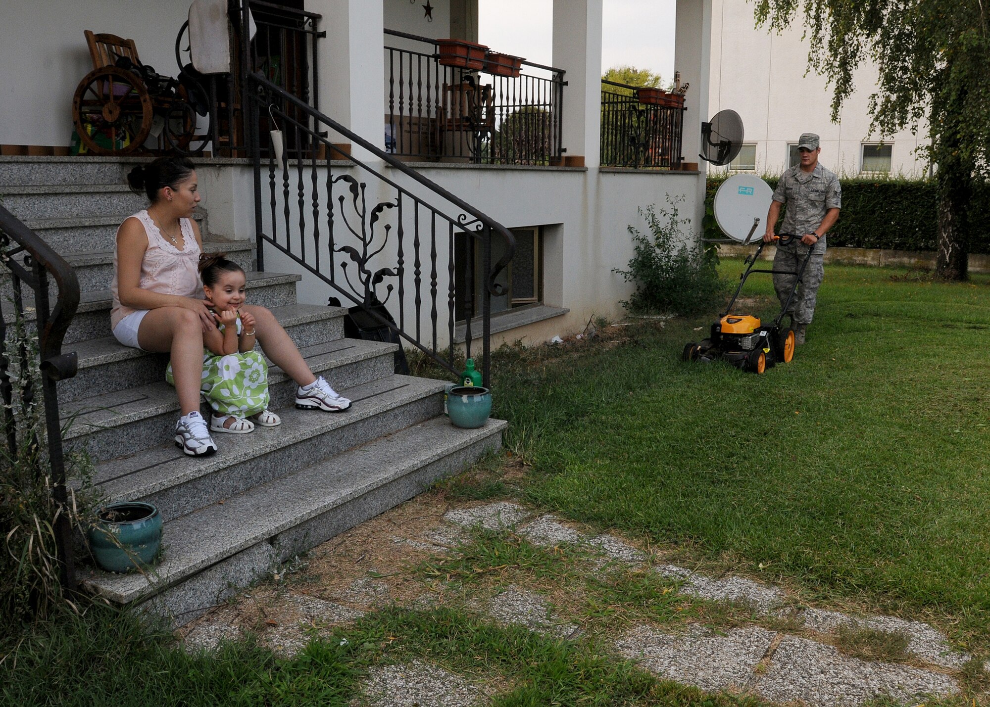 Airman 1st Class Michael Kilburn, 31st Maintenance Squadron Avionics journeyman, mows a lawn Aug. 24 as part of Airmen Support for Families.  This project is designed to help spouses of deployed members with household tasks.  (U.S. Air Force photo/Senior Airman Tabitha M. Lee)