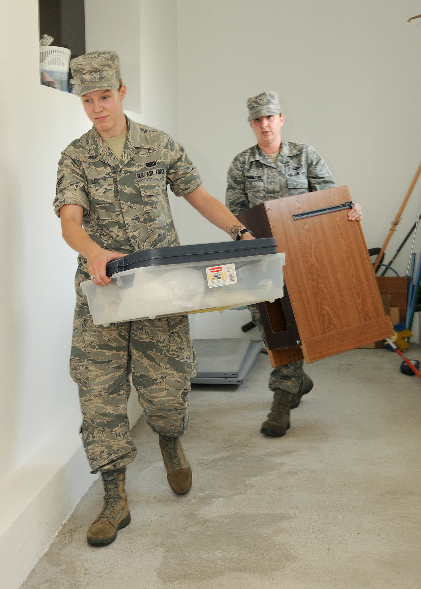 From Left, Senior Airmen Tabitha Lee, 31st Fighter Wing Public Affair photographer, and Airman 1st Class Anna Maria Al Dabbagh, 31st Contracting Squadron contracting specialist, clean out an old storage room at as part of Airmen Support for Families.  Aviano Airmen's Advisory Council Airmen will be providing a list of services including will be providing services, including painting, packing, lifting, cleaning and maintaining lawns.  (U.S. Air Force photo/Staff Sgt. Nadine Barclay)