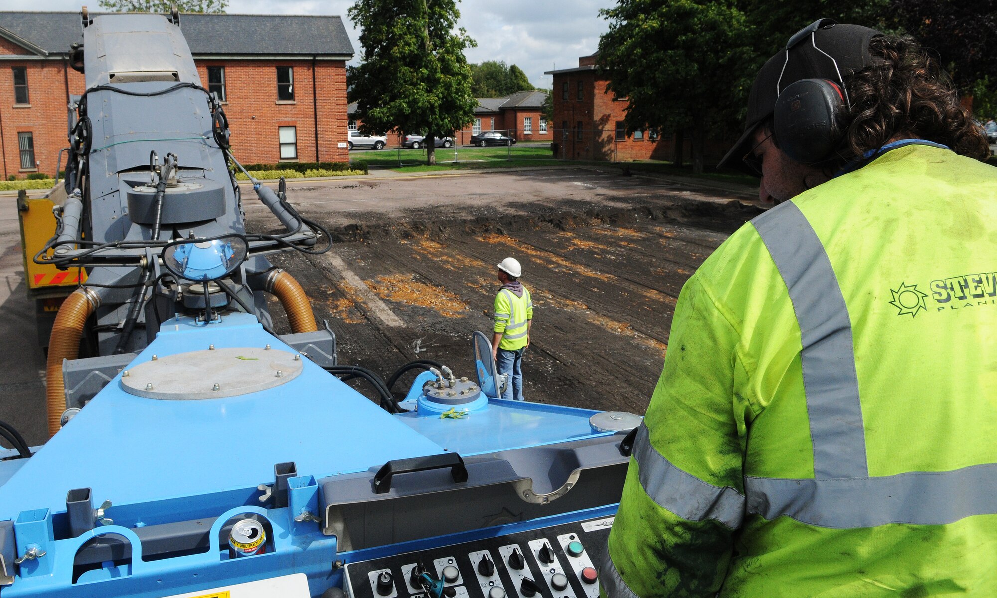 RAF MILDENHALL, England -- David Smith, a local contractor, steers a road planer here in the first stage of demolition of Washington Square. The benefits of the construction are twofold. The site will become a campus-like environment with sidewalks, lawns and trees and the 100th Civil Engineer Squadron can repair sanitation and storm sewers located under the square. (U.S. Air Force photo/Staff Sgt. Thomas Trower)