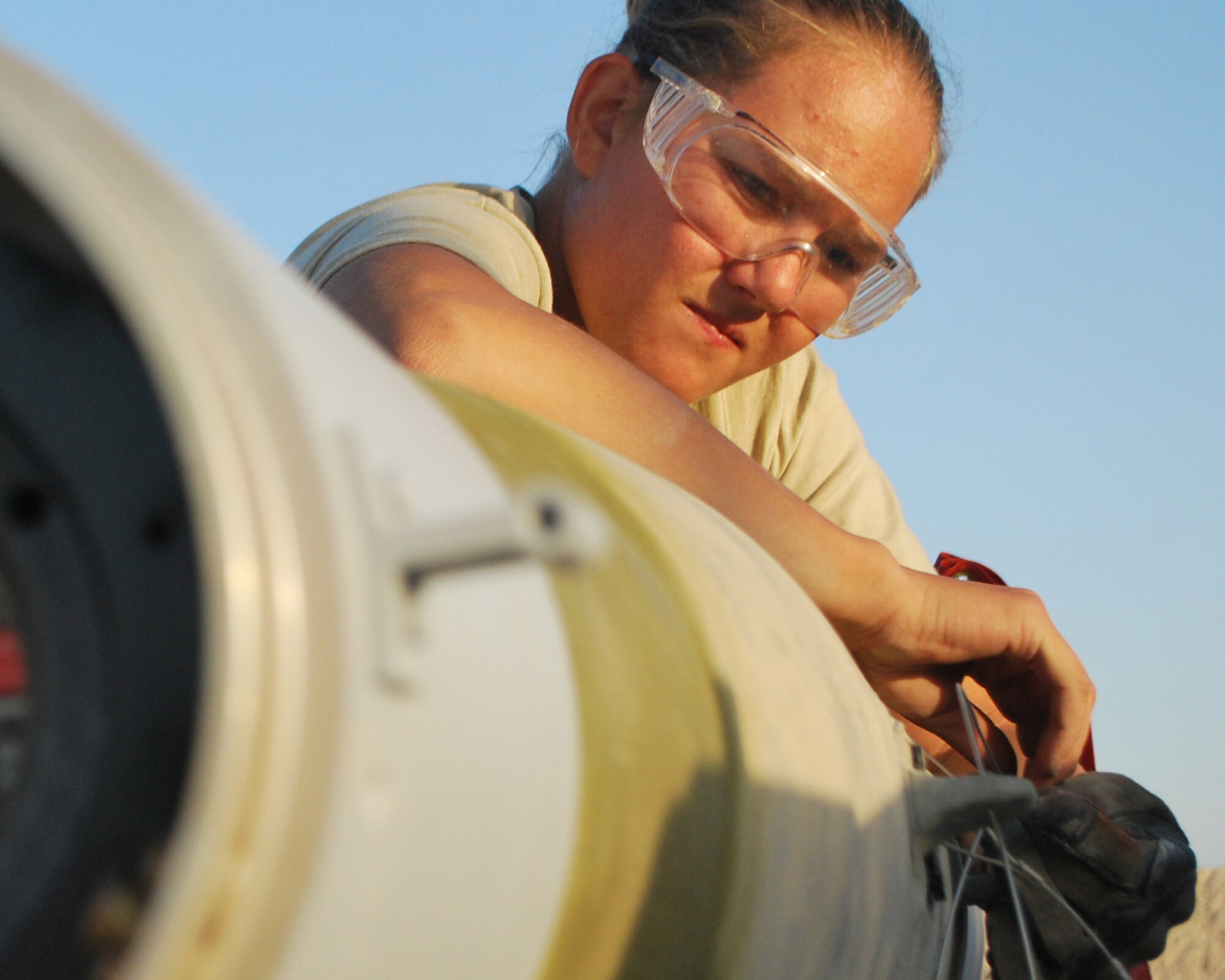 Senior Airman Melissa Bissinger fastens the arming wire on a bomb Aug. 23 at Kandahar Airfield, Afghanistan.  Airman Bissinger is a munitions systems specialist with the 451st Expeditionary Maintenance Squadron Munitions Flight. (U.S. Air Force photo by Senior Airman Melissa B. White/Released)