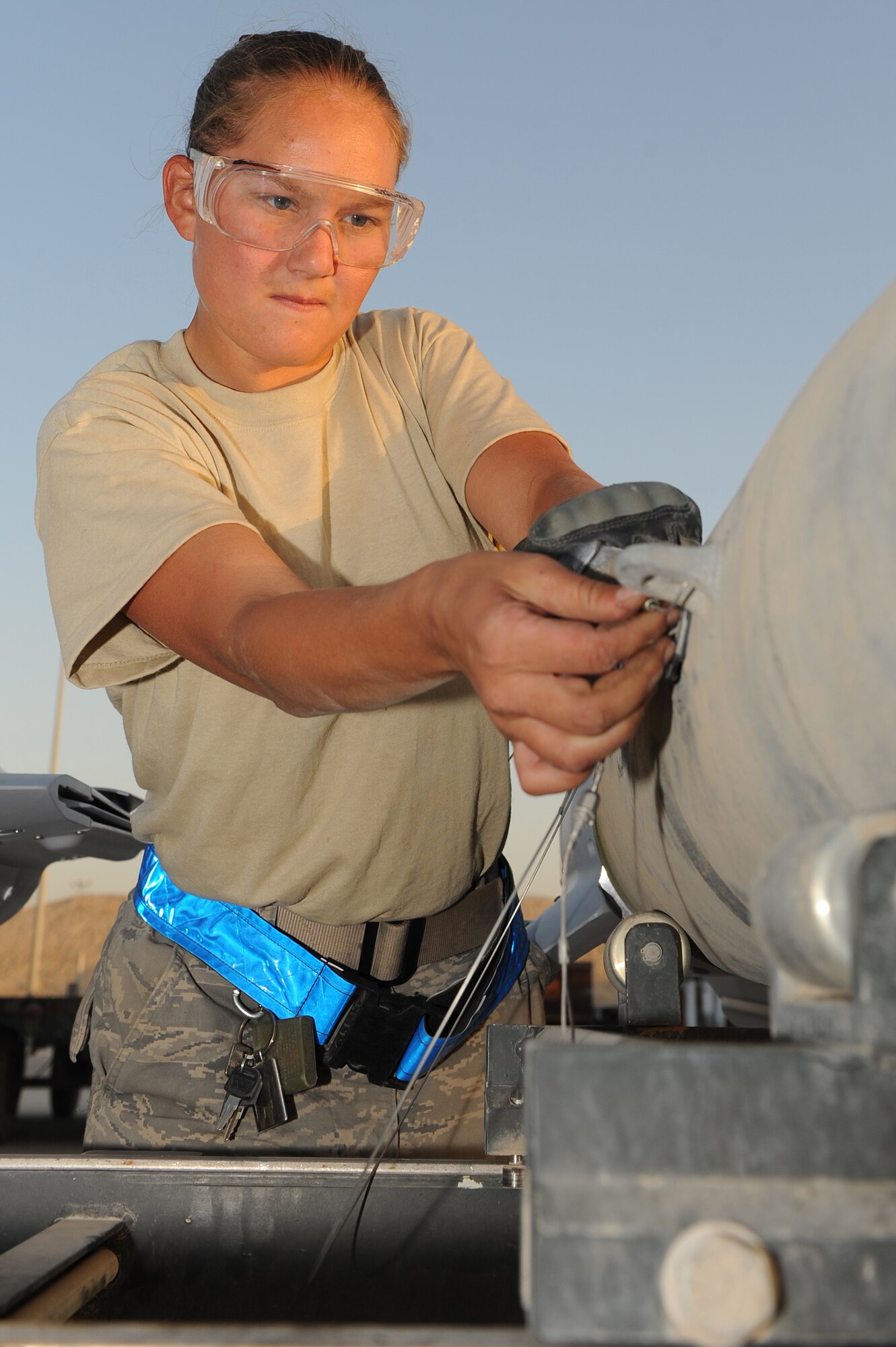 Senior Airman Melissa Bissinger fastens an arming wire to a bomb Aug. 23 at Kandahar Airfield, Afghanistan.   Airman Bissinger is a munitions systems specialist with the 451st Expeditionary Maintenance Squadron Munitions Flight. (U.S. Air Force photo by Tech. Sgt Chad Chisholm/Released)