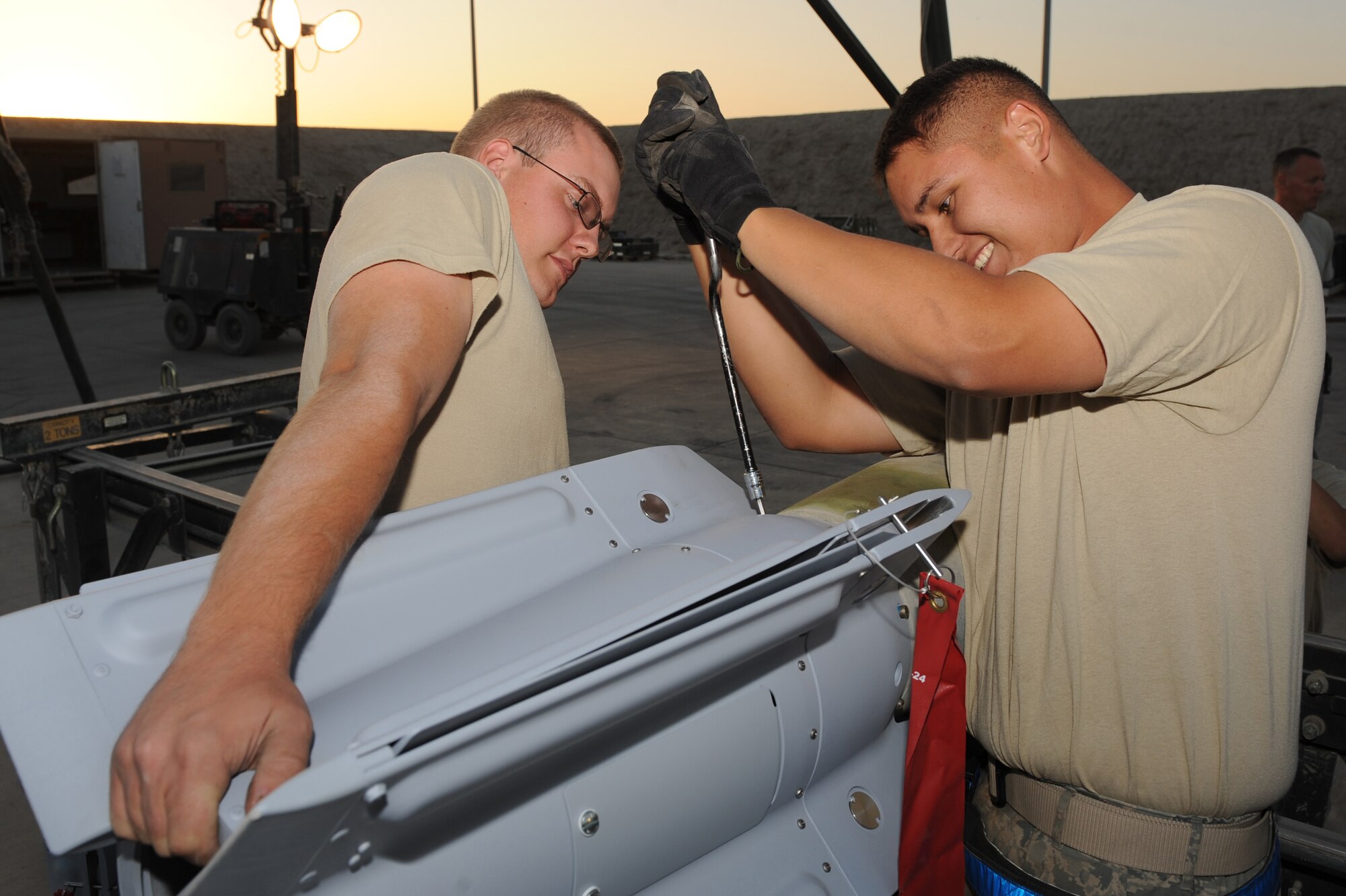 Airman 1st Class Kelle Shadduck (left) and Airman 1st Class Issac Castellon (right) install the wing assembly on a bomb Aug. 23 at Kandahar Airfield, Afghanistan. Airmen Shadduck and Castellon are munitions systems specialists with the 451st Expeditionary Maintenance Squadron Munitions Flight.  (U.S. Air Force photo by Tech. Sgt. Chad Chisholm/Released)