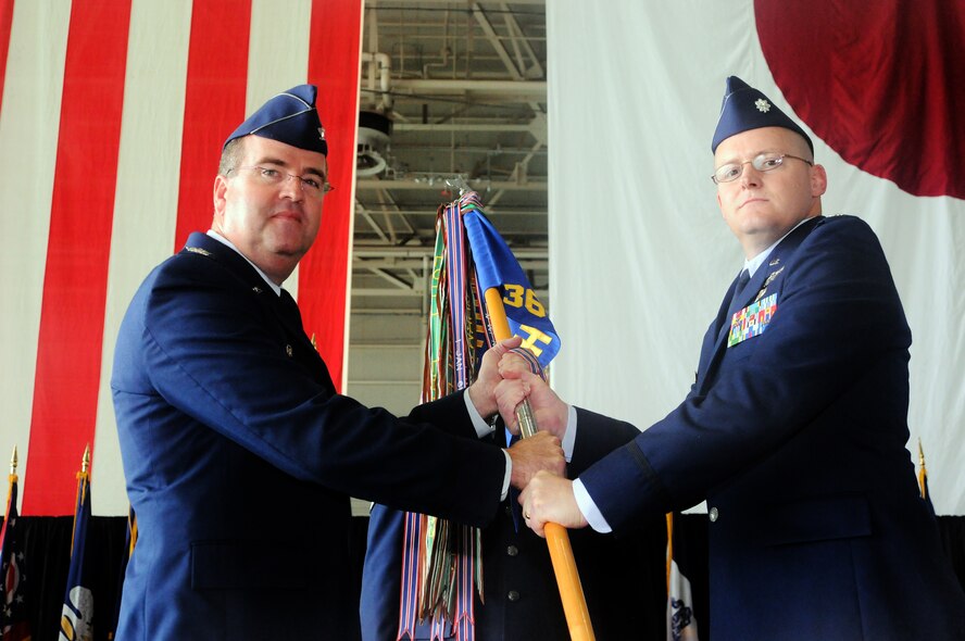 YOKOTA AIR BASE, Japan -- Col. Mark Hering, 374th Operations Group commander presents the guidon to Lt. Col. Timothy Rapp, the incoming 36th Airlift Squadron commander, during the 36 AS change of command, August 26.  (U.S. Air Force photo/Airman 1st Class Katrina R. Menchaca) 