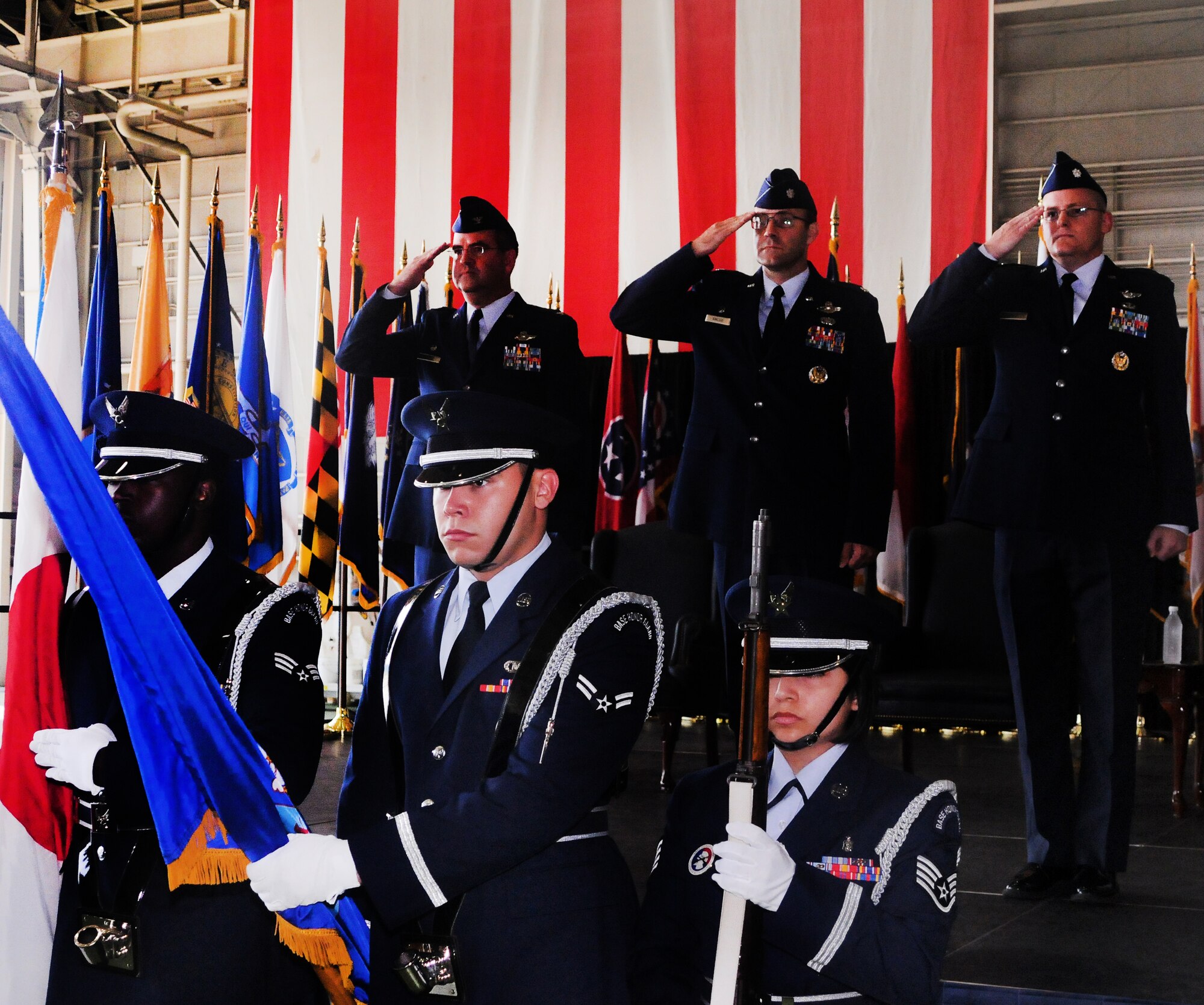 YOKOTA AIR BASE, Japan -- Col. Mark Hering, 374th Operations Group commander, (left) and Lt. Col. David Kincaid, Jr. (center) and Lt. Col. Timothy Rapp, the outgoing and incoming 36th Airlift Squadron commanders, salute the flag as Yokota's Honor Guard present the colors during the 36 AS change of command, here August 26. (U.S. Air Force photo/Airman 1st Class Katrina R. Menchaca)