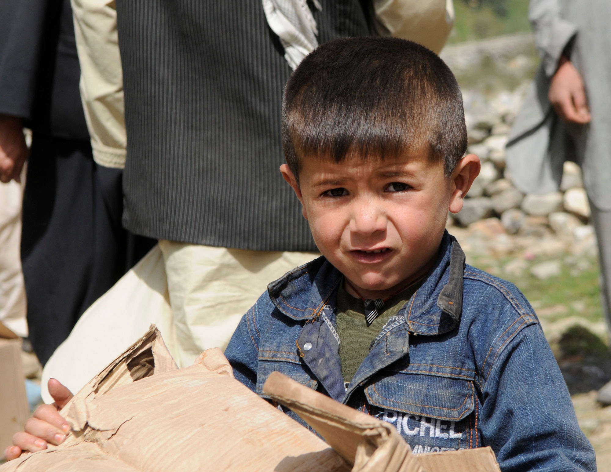 A young boy carries a box of food provided to his family after their village was damaged by a flood in early August.  With the help of the Dara Afghan National Police, the executive district manager of the Abdullah Khel Valley in the Dara District, led the distribution of humanitarian aid consisting of food and cooking items to those affected by the flooding. The local government identified families requiring aid, developed a plan of distribution and executed that plan with minimal Provincial Reconstruction Team  Panjshir oversight. (U.S. Air Force photo by: Tech. Sgt. Sean Mateo White, PRT Panjshir photographer)