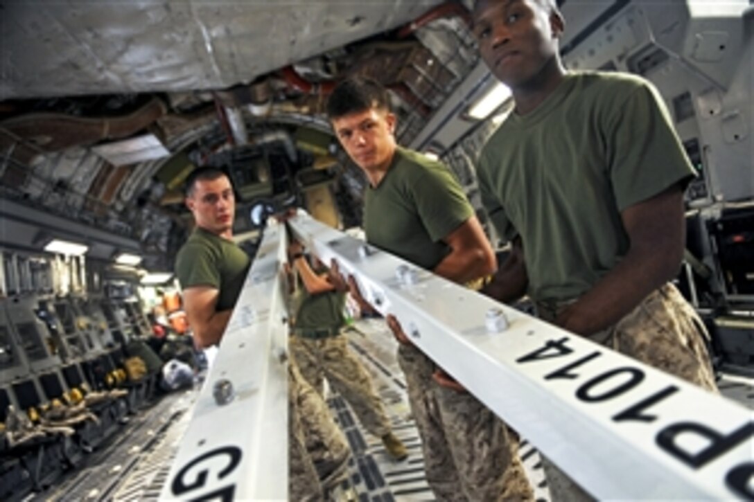 U.S. Marines guide an MH-53E Super Stallion helicopter out of a C-17A Globemaster III aircraft on Camp Bastion, Afghanistan, Aug. 23, 2010.  The helicopter will be used to support flood relief efforts in Pakistan. The Marines are assigned to Marine Medium Tiltrotor Squadron 266.