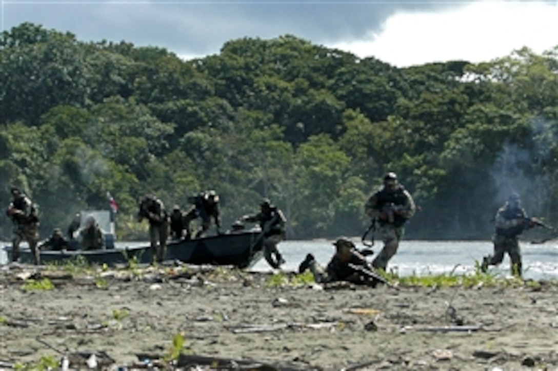 Panamanian marines, U.S. Marines and U.S. Navy sailors storm the beach during the pursuit of three suspected drug traffickers during a PANAMAX training exercise in Panama City, Panama, Aug. 25, 2010. More than 2,000 civilian and military personnel from 18 countries are participating in the 12-day multinational exercise. The U.S. sailors are assigned to Riverine Squadron 3 and the U.S. Marines are assigned to 2nd Fast Company.