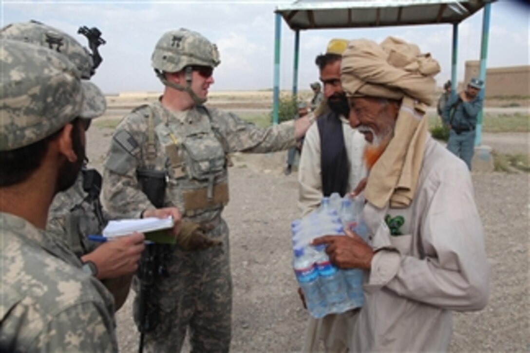 U.S. Army soldiers with Charlie Company, 3rd Battalion, 187th Infantry Regiment, 101st Airborne Division give water to the residents of Khani Kheyl village in western Paktika province, Afghanistan, during a patrol from Forward Operating Base Rushmore on Aug. 20, 2010.  