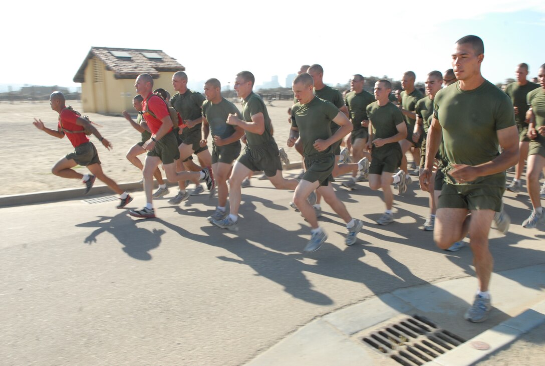 Two drill instructors of Company C start the three-mile run portion of the final PFT with their recruits in order to set a good pace.