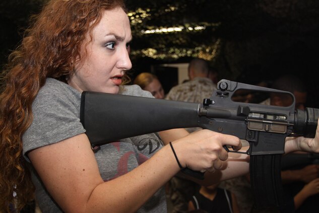 Robbi Dixon, wife of Sgt. James Dixon, aims in with a training M16-A2 service rifle during Combat Logistics Company 36’s Jane/Johnny Wayne Day at the indoor simulated marksmanship trainer here Aug. 27. Wives, girlfriends, mothers and children were able shoot on both the M16-A2 and a 9 mm pistol.