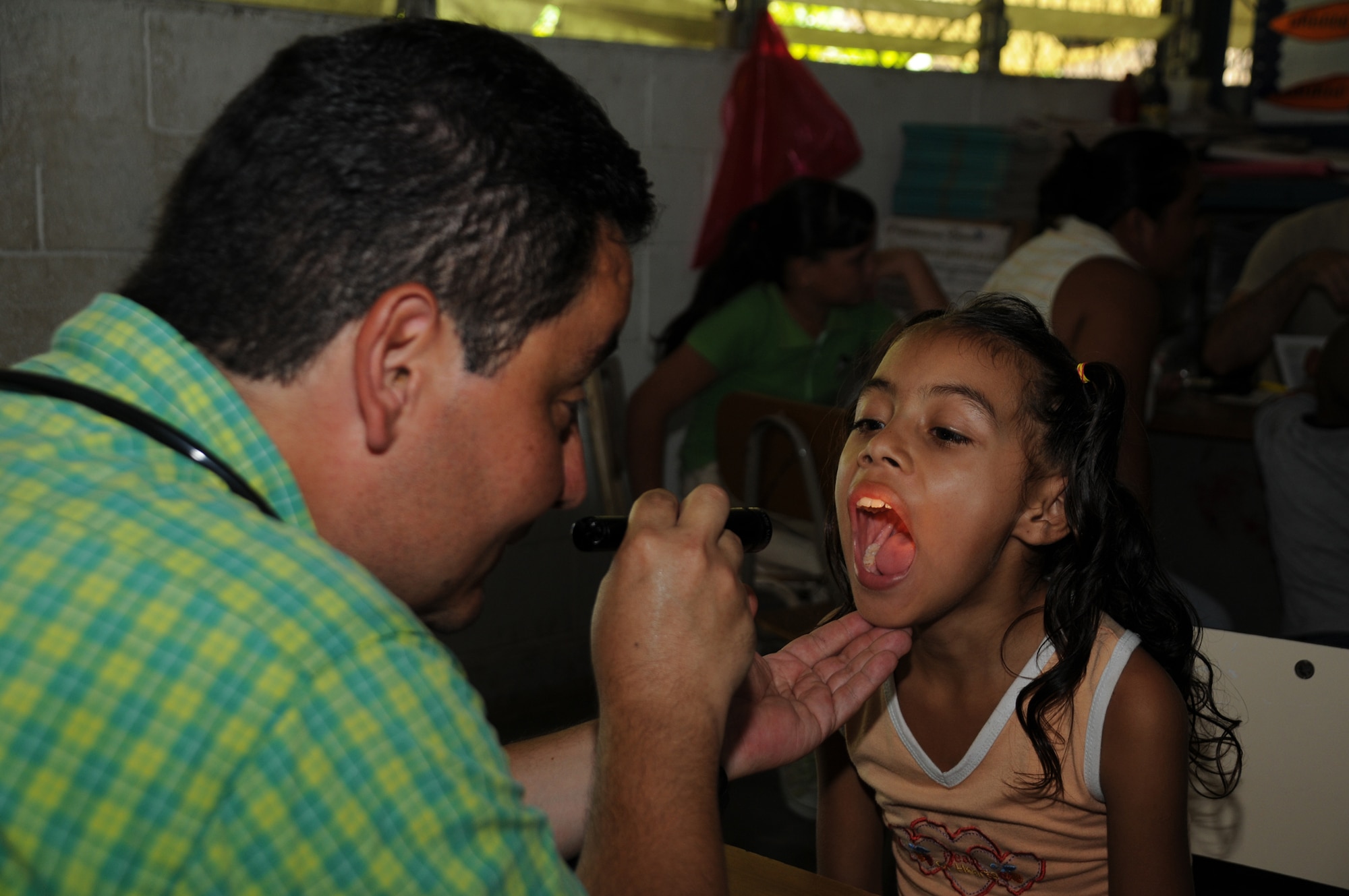 SAN CARLOS LEMPA, El Salvador --  Giving a young patient a thorough check-up, Dr. Carlos Duron, with the Joint Task Force-Bravo Medical Element, checks patients who made need extra care during the medical civic action program here Aug. 25. Team Bravo medical professinals assisted the El Salvador Ministry of Health and military in treating almost 800 patients here. (U.S. Air Force photo/Tech. Sgt. Benjamin Rojek)
