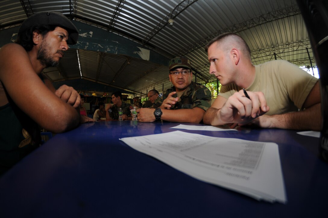 SAN CARLOS LEMPA, El Salvador --  Working with an El Salvador military medic, Staff Sgt. John Bartlett, with the Joint Task Force-Bravo Medical Element, screens patients during the medical civic action program here Aug. 25. Team Bravo medical professinals assisted the El Salvador Ministry of Health and military in treating almost 800 patients here. (U.S. Air Force photo/Tech. Sgt. Benjamin Rojek)