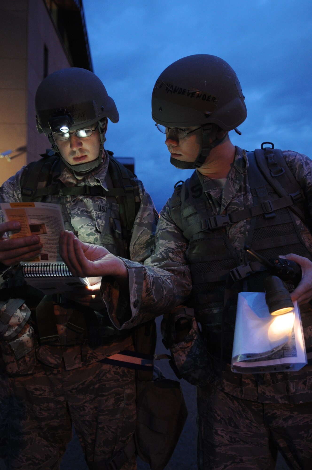 U.S. Air Force Staff Sgt. Joshua Medlin and Justin Vandevender, 1st Combat Communication Squadron, review their Airman's Manual during an operational readiness exercise, Ramstein Air Base, Germany, Aug. 26, 2010. An ORE incorporates a series of scenarios to evaluate a base's ability to execute operational duties under simulated wartime conditions. (U.S. Air Force photo by Airman 1st Class Brittany Perry)