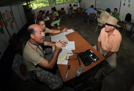 EL PICHICHE, El Salvador --  Dr. (Col.) Michael Friedman, left, with the Joint Task Force-Bravo Medical Element, consults with patient as Capt. Javier Rodriguez, of the JTF-Bravo J3, helps translate during the medical civic action program here Aug. 24. Team Bravo medical professionals assisted the El Salvador Ministry of Health and military in bringing medical care to more than 400 people in this remote village. (U.S. Air Force photo/Tech. Sgt. Benjamin Rojek)
