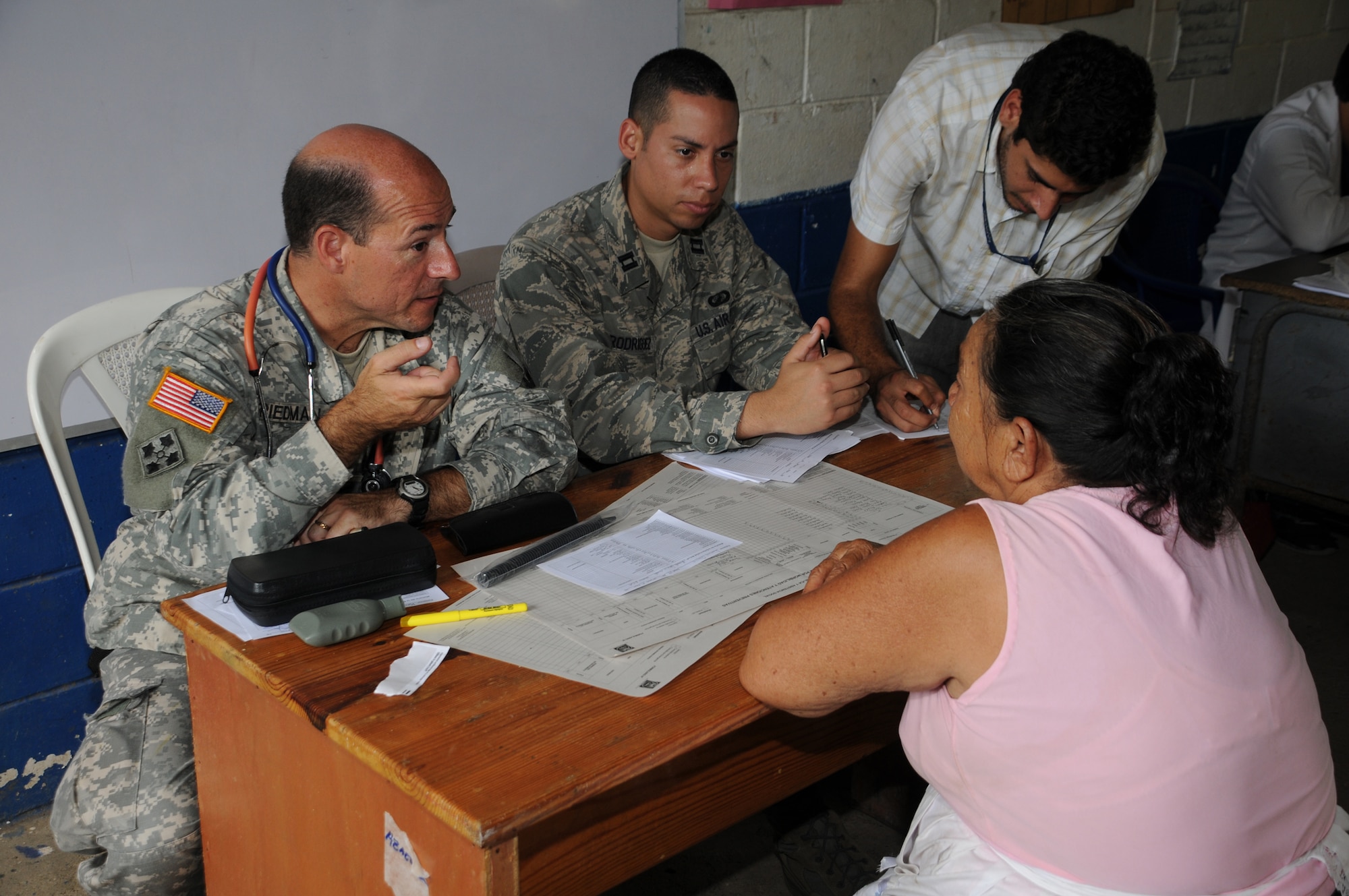 EL PICHICHE, El Salvador --  Dr. (Col.) Michael Friedman, left, with the Joint Task Force-Bravo Medical Element, consults with patient as Capt. Javier Rodriguez, of the JTF-Bravo J3, helps translate during the medical civic action program here Aug. 24. Team Bravo medical professionals assisted the El Salvador Ministry of Health and military in bringing medical care to more than 400 people in this remote village. (U.S. Air Force photo/Tech. Sgt. Benjamin Rojek)