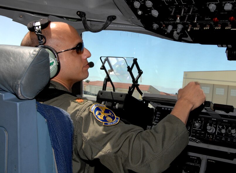 A member of the 349th AMW sits in the pilot's seat on the flightline.