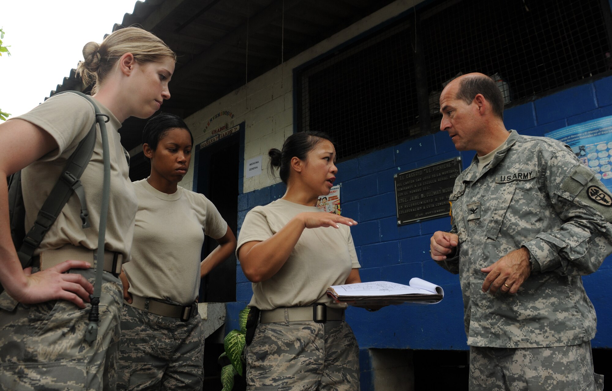 EL PICHICHE, El Salvador -- Shortly after arriving at the make-shift clinic site, 1st Lt. Nicole Musshorn, Senior Airman Jessica Keahey, Master Sgt. Judy Santa Ana-Christian and Dr. (Col.) Michael Friedman work out the day's traffic flow here Aug. 24 for a medical civic action program. The Team Bravo members assisted the El Salvador Ministry of Health and military in bringing medical care to this remote village, including preventative medicine and pharmacy care. (U.S. Air Force photo/Tech. Sgt. Benjamin Rojek)