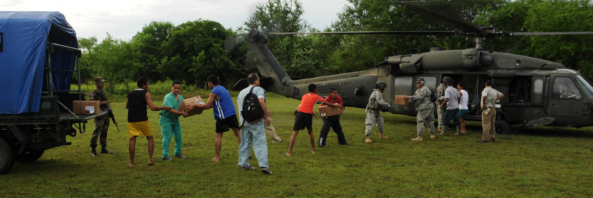 EL PICHICHE, El Salvador --  In a field outside the village here, Team Bravo members and local volunteers unload medical nal supplies after arriving here Aug. 24 for a medical civic action program. The Team Bravo members assisted the El Salvador Ministry of Health and military in treating more than 400 patients in this village near the coast. (U.S. Air Force photo/Tech. Sgt. Benjamin Rojek)