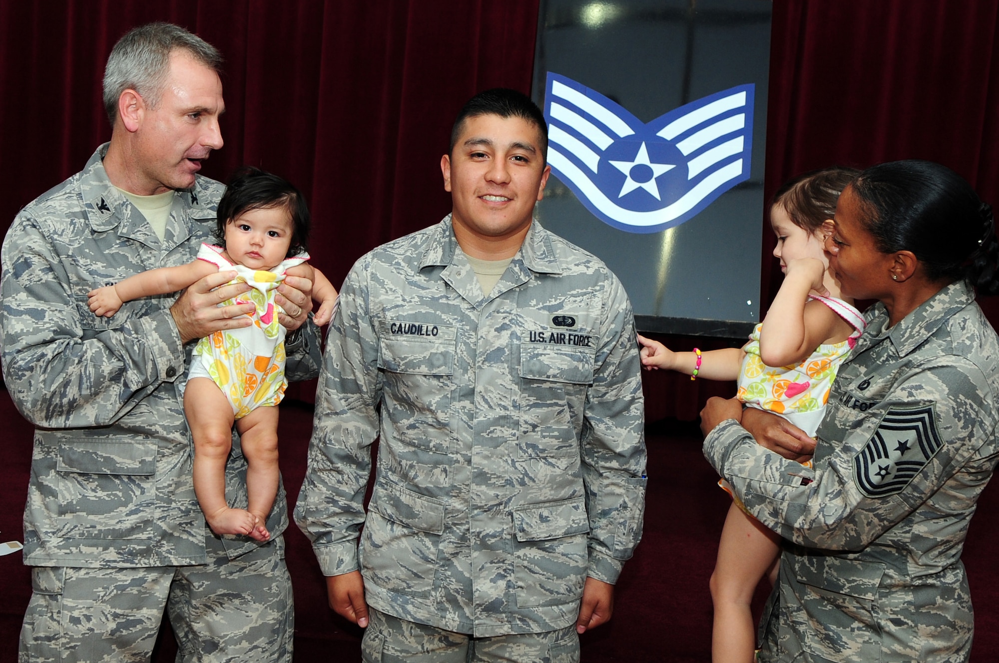 BARKSDALE AIR FORCE BASE, La. ? Col. Timothy Fay, 2d Bomb Wing commander and Chief Master Sgt. Joe Ann Pace, 2d BW command chief, help the children of Senior Airman Jeremy Caudillo, 2d Force Support Squadron, tack on his new staff sergeant stripes during the staff sergeant selection party held at the Stripes Club Aug. 26. (U.S. Air Force photo by Senior Airman Joanna M. Kresge)