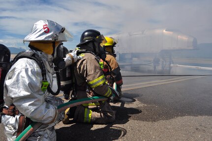 SOTO CANO AIR BASE, Honduras --  With smoke billowing from an "aircraft," firefighters from the 612th Air Base Squadron, Honduras and Guatemala work together to put out a blazing fire during the Central America Sharing Mutual Operational Knowledge and Experiences exericse here Aug. 24. This was the first time Guatemala participated in the annual exercise. (U.S. Air Force photo/Martin Chahin)