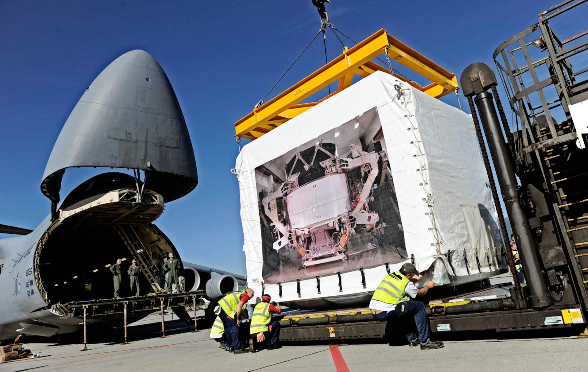 A C-5M Super Galaxy, based out of Dover Air Force Base, Del., is loaded with the Alpha Magnetic Spectrometer Aug. 25, 2010, at the Geneva airport. The AMS is the brain child of Nobel laureate, Dr. Samuel Ting and has been in production for 16 years. The purpose of the experiment is to detect and analyze particles found in space while docked to the International Space Station. (U.S. Air Force photo/Staff Sgt. Ryan Crane)