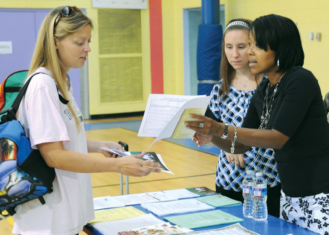 JOINT BASE ANDREWS, Md. -- Carina Lewis, wife of Staff Sgt. Nick Lewis, 89th Communications squadron, left, receives information about special needs programs from Melonee Clark, family specialist, The Arc of Prince George's County, right, Aug. 25. Ms. Clark, Teresa Robinson, and Becky DeWright represented The Arc of Prince George's County at Joint Base Andrews Exceptional Family Members Program Fair. The fair was sponsored to inform the base population of various resources available for active duty family members with developmental disabilities.   (U.S. Air Force photo Staff Sgt. Keyonna Fennell)