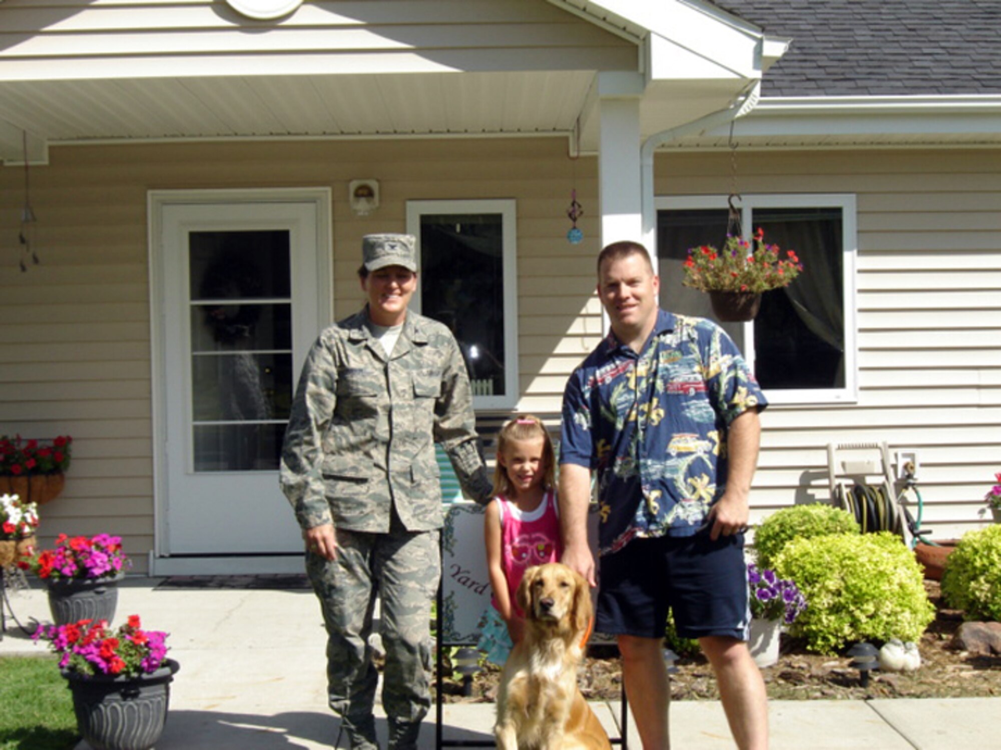 Col. Tammy Knierim, 319th Mission Support Group commander, presents Master Sgt. David Fugiel, 319th Logistics Readiness Squadron, and his daughter with the July 2010 Yard of the Month, Senior NCO Category. The yard of the month program recognizes the hard work and effort of base residents that exceed the yard maintenance standards. (Courtesy photo)